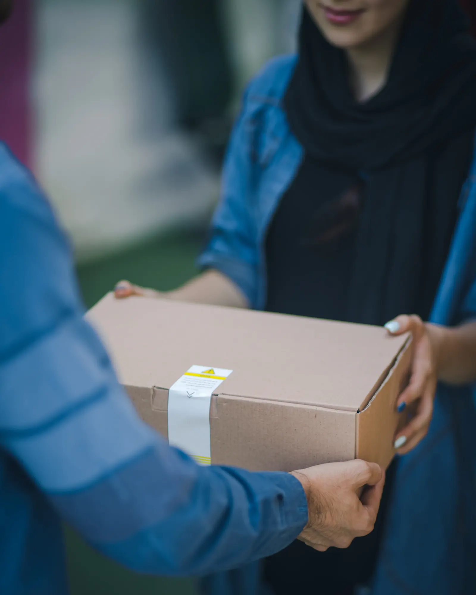 A carefully handled package being transferred between two people